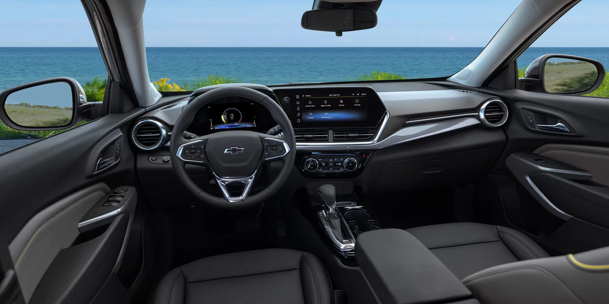 2026 Chevrolet Trax parked outdorrs near body of water, image showing front row of vehicle
