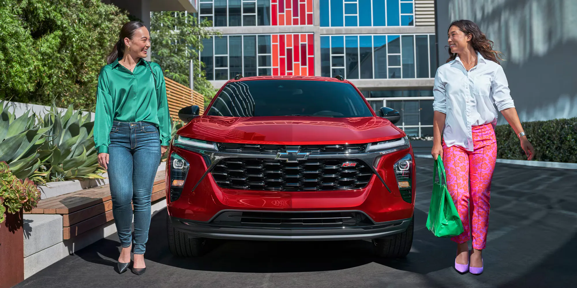 Unknown people walking next to 2026 Chevrolet Trax outdoors